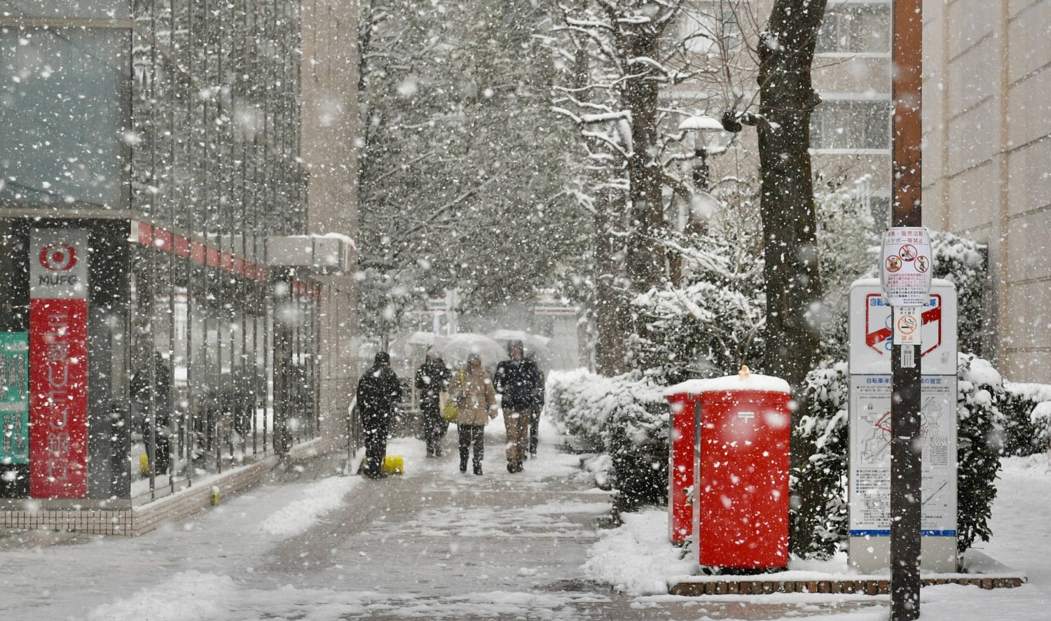 Snow falls outside of Shin-Yurigaoka Station in Kawasaki on Sunday morning.